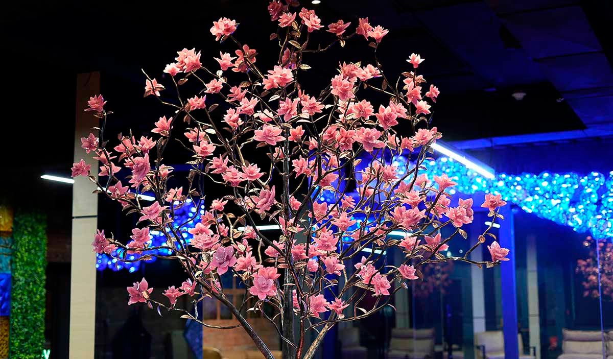 Public art in the form of a tree with pink magnolia flowers made of art glass in a modern interior