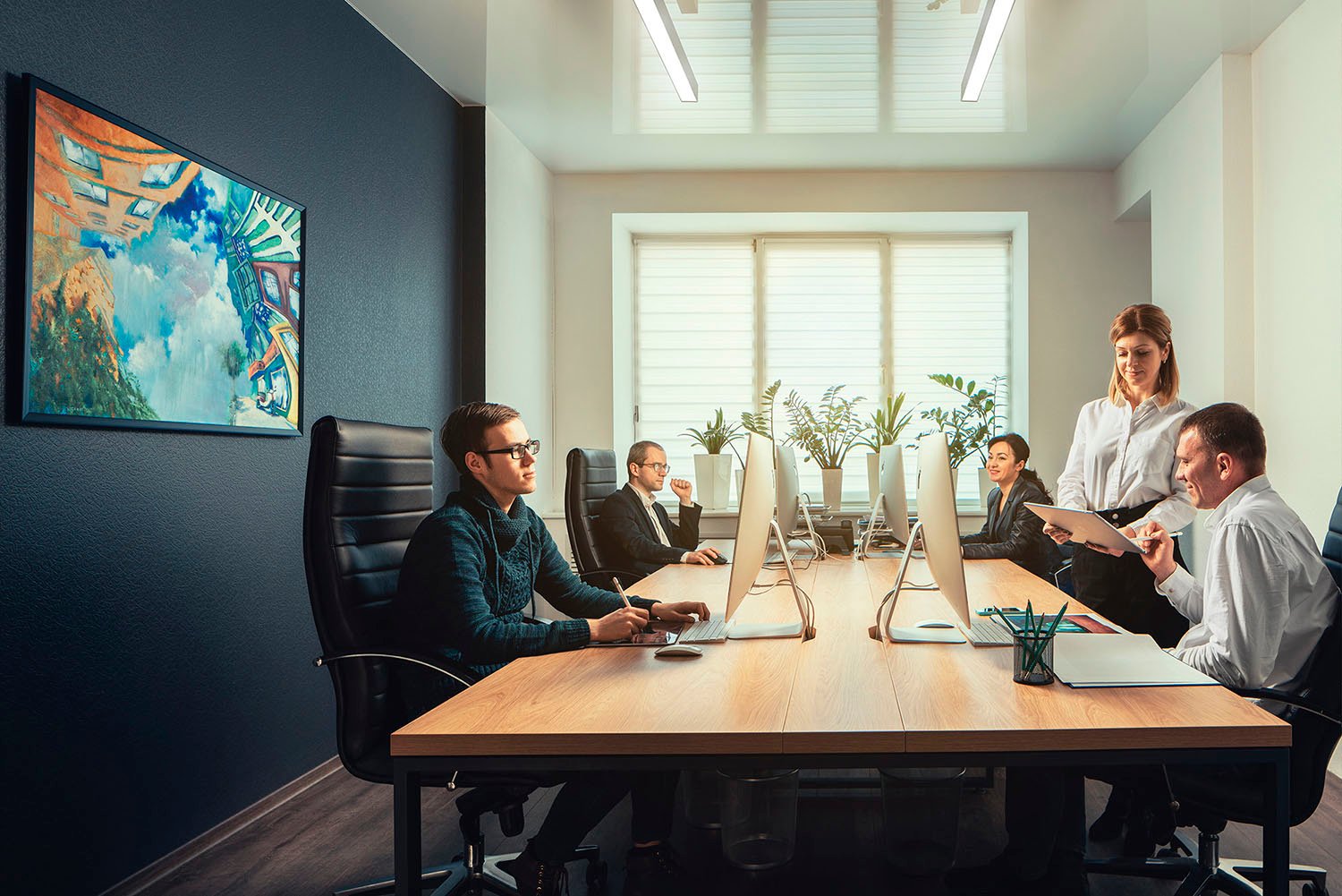 Modern open-space office of SKYFORM STUDIO with employees working at computers and discussing documents, bright interior with plants.”