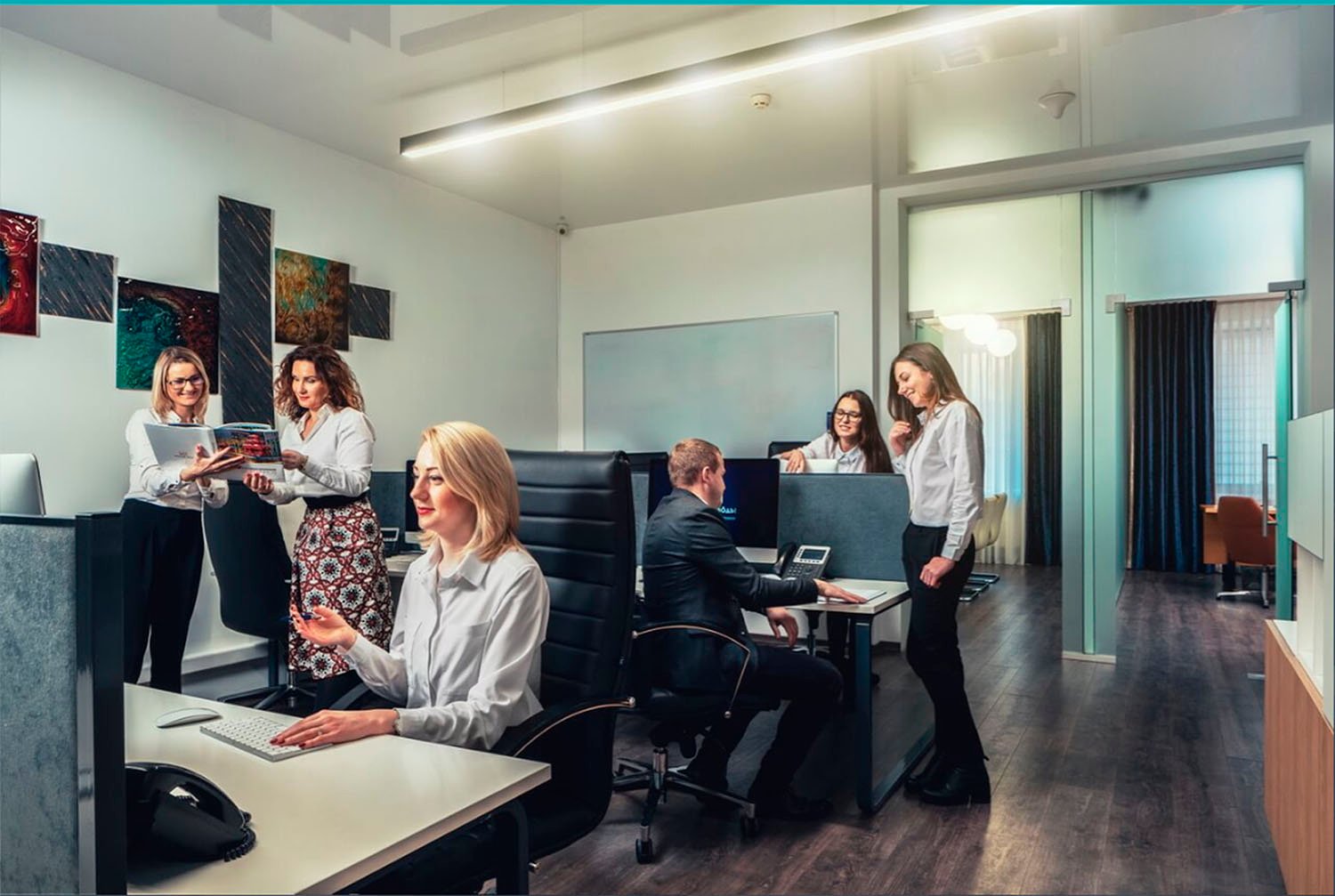 Employees of SKYFORM STUDIO working in an open office space, group discussions near desks, modern interior with art on the walls.