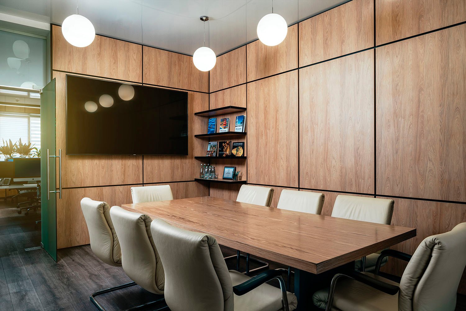 Modern meeting room at SKYFORM STUDIO with wooden walls, large screen, bookshelf, and leather chairs around conference table