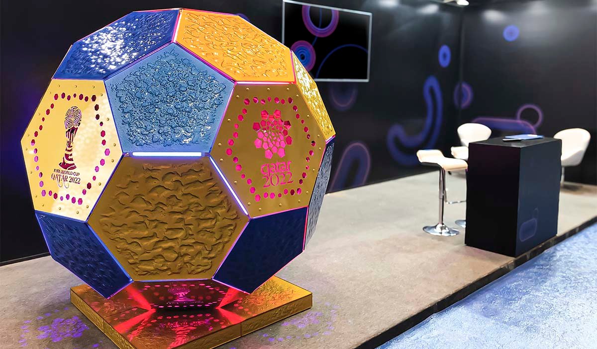 A polyhedron-shaped art installation made of art glass featuring the FIFA World Cup Qatar 2022 logo.