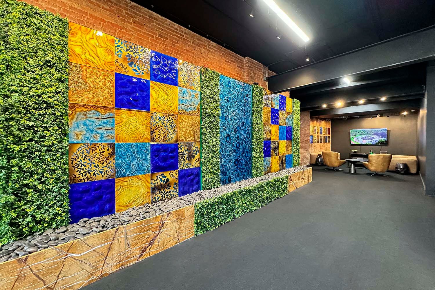 Artistic feature wall in SKYFORM STUDIO showroom with golden and blue textured panels, greenery accents, and lounge seating area.
