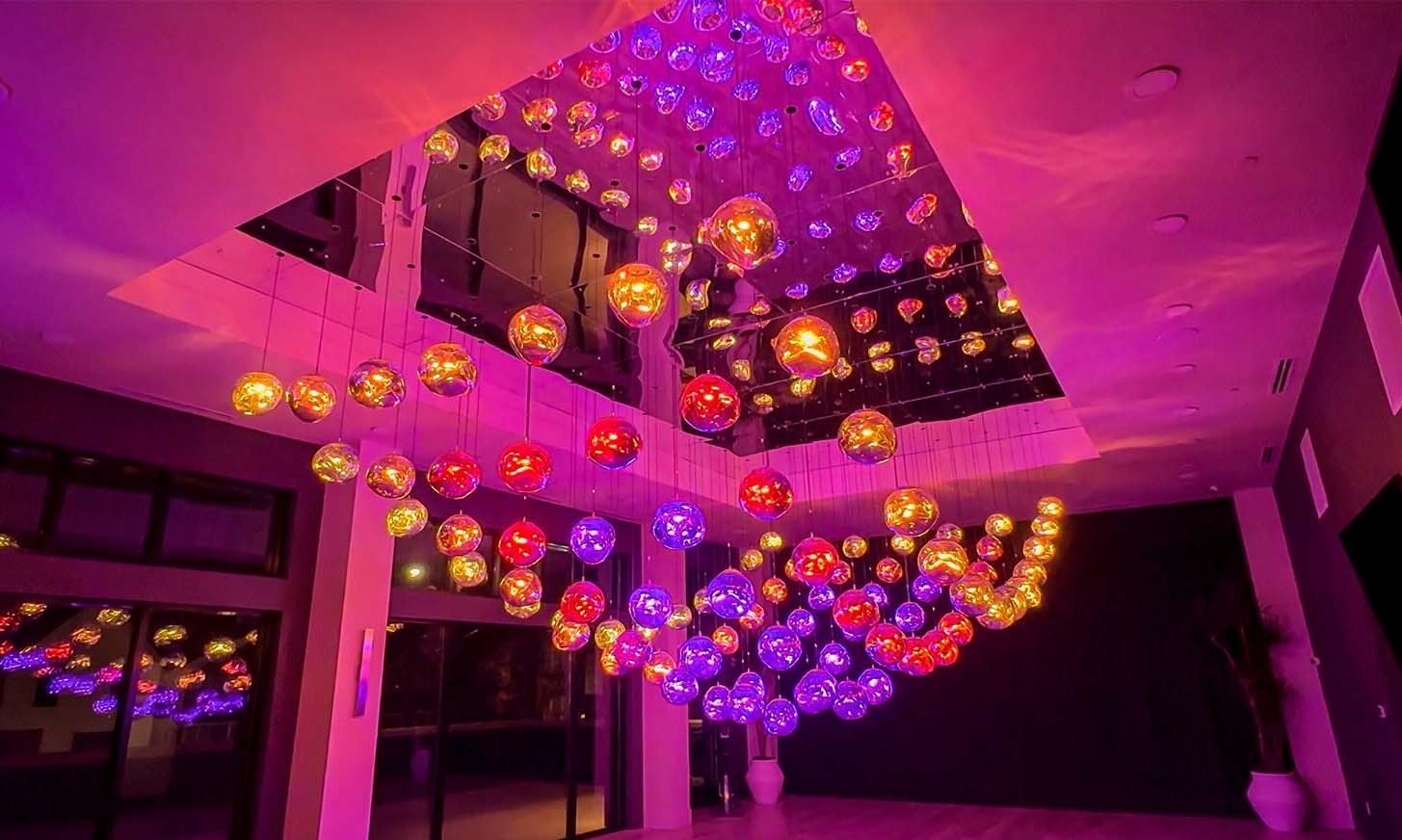 Interactive kinetic light sculpture made of illuminated glass spheres, art installation for modern interiors.
