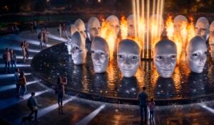 Ночная инсталляция «Симфония отражений» — 16 скульптурных лиц над водной платформой, подсвеченные огненными вспышками и вертикальными световыми лучами.