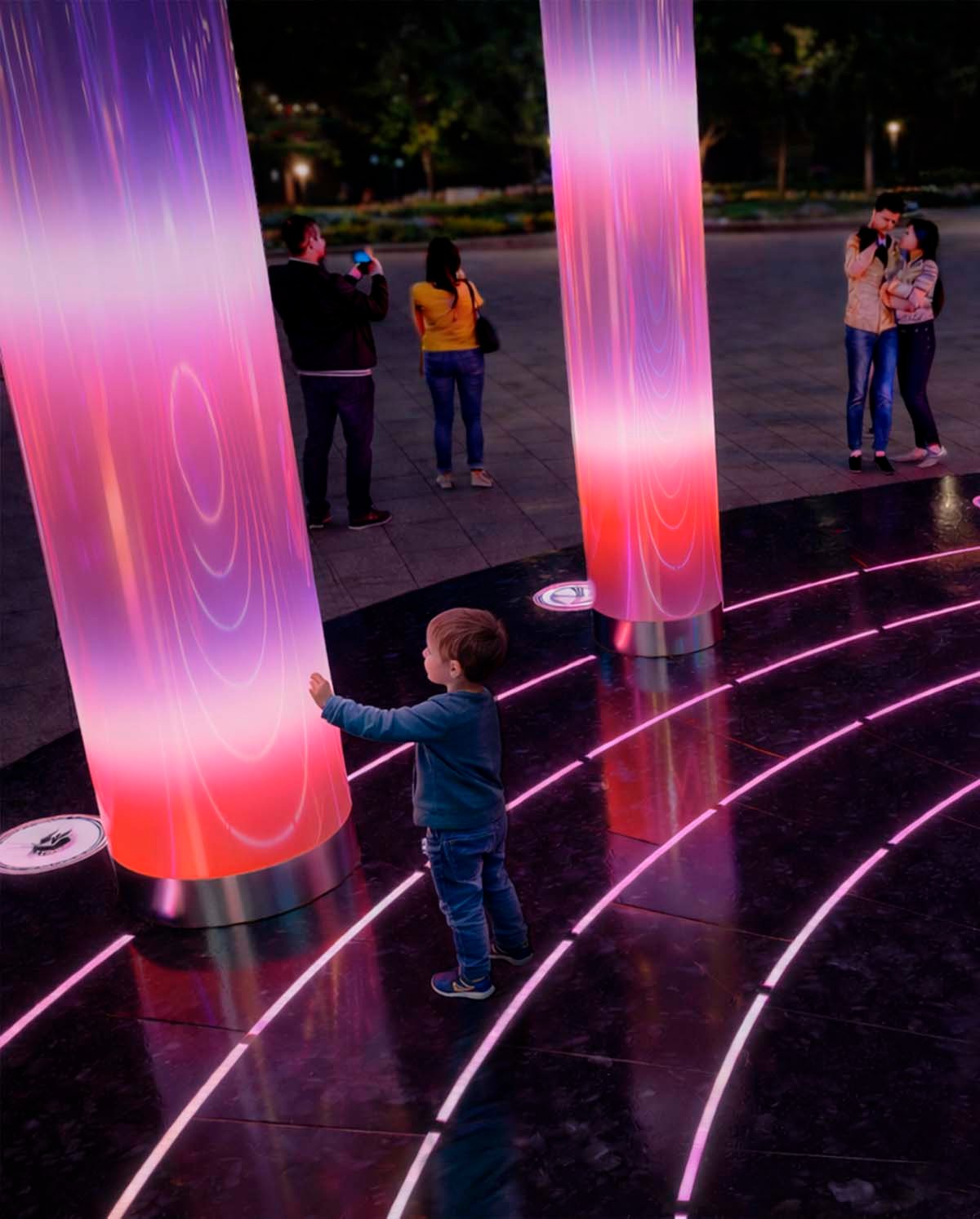 An interactive light installation in an urban space: a child touches a glowing column with dynamic pink-purple gradients, surrounded by light lines in a granite coating and visitors interacting with the object in the evening.