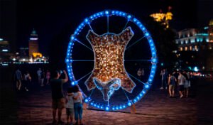 Public art installation “Golden Fleece” in the form of a ram with a golden frame, illuminated by RGB lighting.